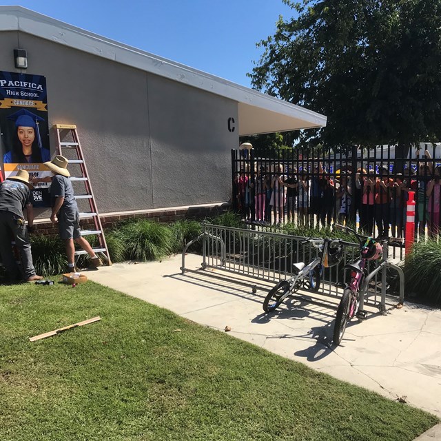 Scott and John from structural Maintenance Dept install college banners to the delight of our college bound Kinder students... who were writing about tools!